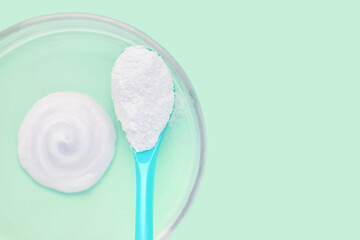 Collagen white powder. Pastel color background. Health product. Woman cosmetics concept. Sport supplement. Skincare cosmetics. Light green. Cream smear. Spoon