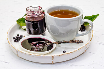 Elderberry jam from ripe berries and hot tea