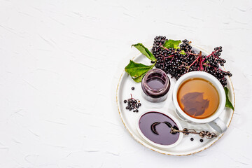 Elderberry jam from ripe berries and hot tea