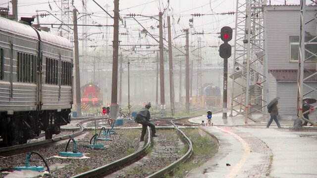 railway station in the rain receives and sends passenger trains