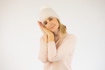 Woman wearing casual sweater sleeping tired dreaming and posing with hands together