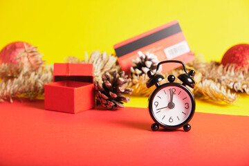 small black alarm clock, credit card and christmas decor on background, copy place, christmas shopping concept, shopping before new year