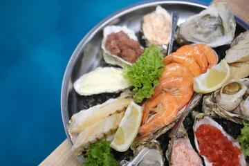 a plate of assorted seafood on a blue background in top view