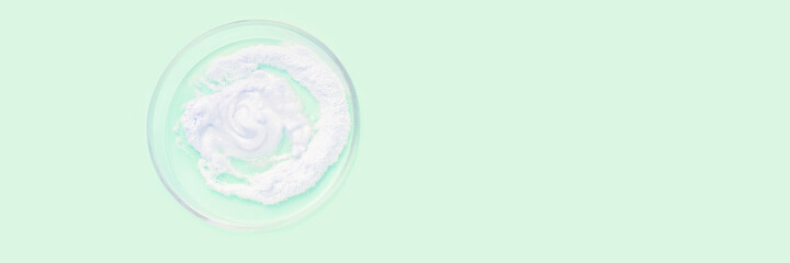 Collagen white powder. Pastel color background. Health product. Woman cosmetics concept. Sport supplement. Skincare cosmetics. Light green. Horizontal banner