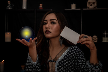 Fortune-teller woman is predicting with a shining crystal ball with Gypsy card. Fortune telling and...