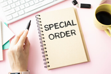 Text sign showing Special Order. A special item requested by the military headquarters for a daily note. White computer keyboard with a blank sheet for notes on a light background.