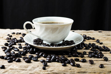 Coffee cup and coffee beans on rustic wooden background.