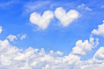Fototapeta na wymiar Two heart shaped clouds on blue sky 