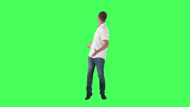 Amazed young smart casual man looking back and around for shopping offers. Full body on green screen. 