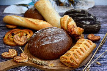 Bread, rolls, baguette, pastries on a rustic wooden background. Close-up