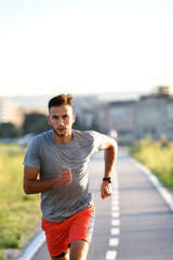 Fototapeta premium Sports man running fast outdoors on a race track
