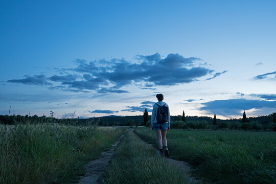 femme qui marche sur un chemin de campagne à la tombée de la nuit dans le sud de la France