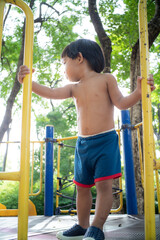 Little boy playing on playground park enjoying slider