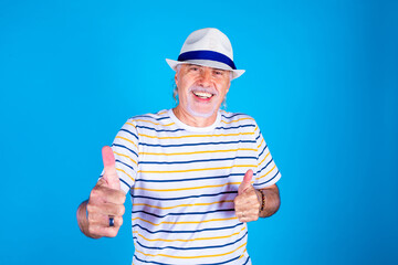 Senior male on blue background positive having fun blessing - Old man isolated smiling gesturing agreement - positive, funny, blessing concept