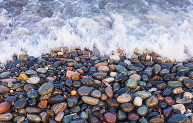 Shiny wet pebbles in the surf. Close-up.