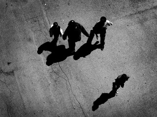 Fototapeta na wymiar People walking below looking down from above concrete shadows