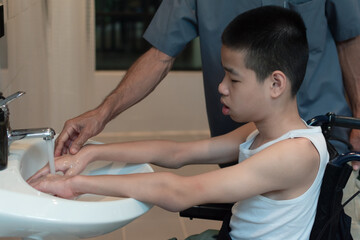 Happy asian disabled on wheelchair wash hands for hygiene and prevent the spread of communicable diseases Covid 19 or Coronavirus, New normal lifestyle to prevent the spread of the virus disease 2020.