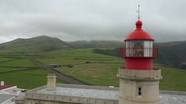 Drone view of Albarnaz Lighthouse in Flores Island, Azores. Foggy weater and cloudy sky