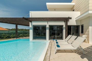 Fototapeta na wymiar Modern house with garden swimming pool and wooden pergula