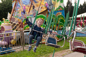 Obraz na płótnie Canvas boy riding a carousel in an amusement park