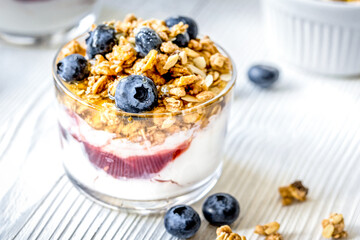 Morning granola with yogurt and berries on white kitchen background