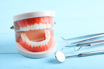model of teeth and dental instruments and dental care products on colored background
