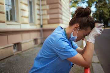 stressed modern physician woman outdoors near hospital