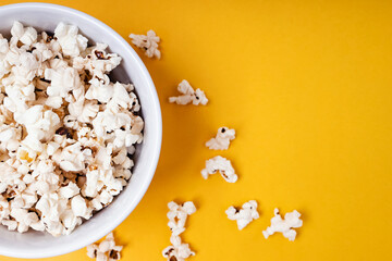 Bowl of popcorn on yellow background