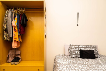 Double bed and closet with women's clothing