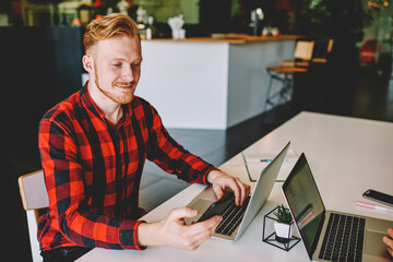 Successful male IT professional using digital smartphone for installing bluetooth application and...