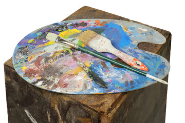 Colorful palette with brushes and painter's knife on a rusty brown stand