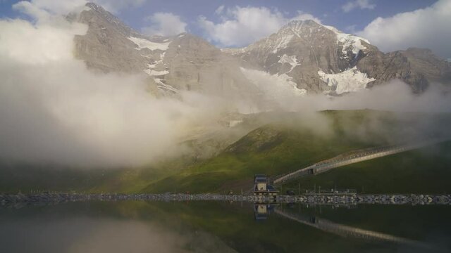 Scenic View Of The Misty Fallbodensee Lake With Railway Line On The Swiss Mountains Leading To Jungfraujoch, A Saddle In The Bernese Alps In Switzerland, Top Of Europe - hyperlapse