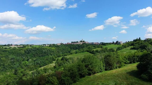 Flying towards Murazzano - an aerial passage above the surrounding green countryside of a small typical village of Piedmont