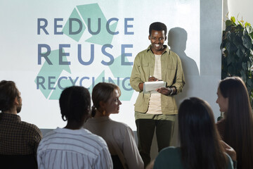Portrait of smiling African-American man giving speech on recycling and waste management during...