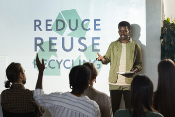 Portrait of young African-American man giving speech on recycling and waste management during...