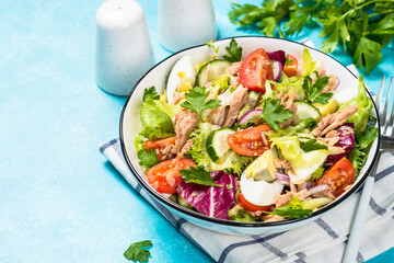 Tuna salad with green leaves, eggs and vegetables.