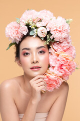 Beauty Asian young woman with big bouquet flowers on head smile with clean fresh skin Happiness and cheerful with positive emotional on Beige background,Beauty Cosmetics and Facial treatment Concept