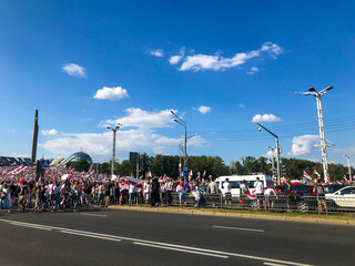 peaceful march in the city center by the stella. men and women carry a large white-red-white flag...