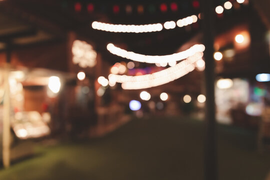 Blurred images of food night market streets party in the park, bokeh light, and vintage festival background.