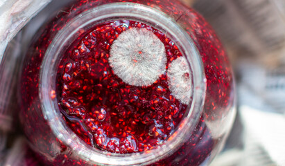 Mold in a jar of raspberry jam. Hazardous to health. - obrazy, fototapety, plakaty