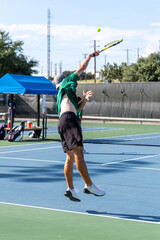 Boy serving the ball during a tennis match