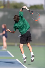Boy serving the ball during a tennis match