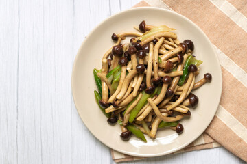 Yanagi Mutsutake (Japanese mushroom) stir-fried with oyster sauce isolated on grey table background. Healthy meal.