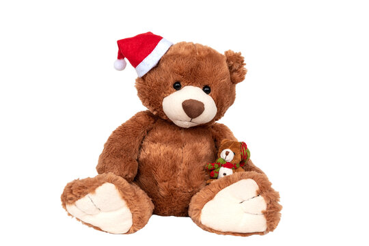 Plush brown bear wearing Santa Claus hat holding small kid. Christmas and New Year celebration. Family winter holidays warmth and love. Plaything for children, present gifts for kids on xmas