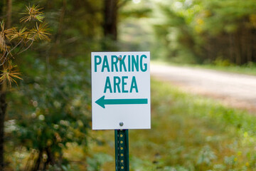 Sign indicating parking area in a rural woodland area 
