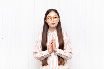 asian young woman feeling proud, mischievous and arrogant while scheming an evil plan or thinking...