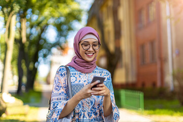 Confident young woman wearing hijab with mobile phone
