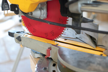 Building contractor worker using hand held  circular saw to cut boards on a new home constructiion project site