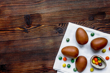 Easter chocolate eggs top view on wooden background mock up