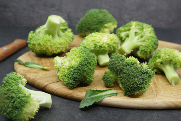 Green fresh broccoli on a wooden cutting board. Organic food preparation. Vegetables for healthy eating. Closeup